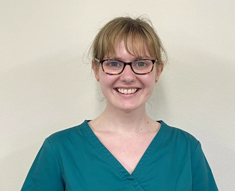 Smiling person in scrubs